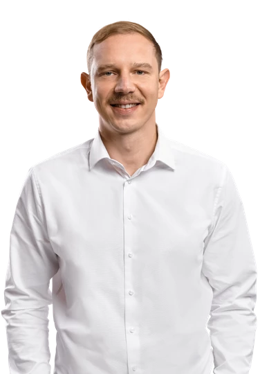 Porträt eines Mannes in weißem Hemd, lächelnd, von Brust bis Schultern sichtbar.