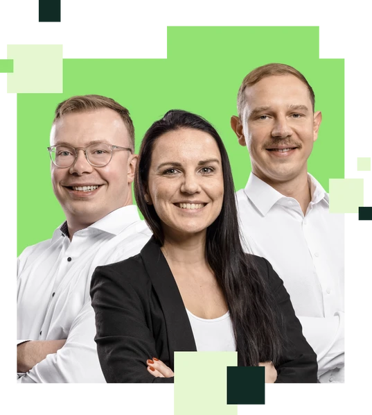 Vier Personen in weißen Hemden stehen nebeneinander vor grünem Hintergrund und lächeln.